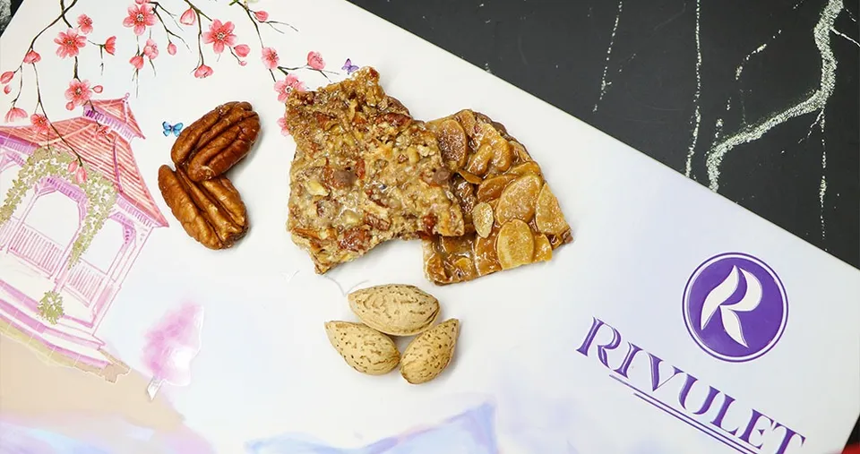 ألواح من الكاكاو البلجيكي الفاخر مغطاة بطبقة مكرملة من قطع جوز البيكان أو شرائح اللوز