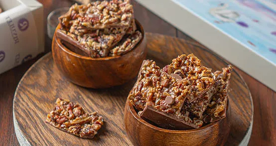 ألواح من الكاكاو البل جيكي الفاخر مغطاة بطبقة مكرملة من قطع جوز البيكان أو شرائح اللوز
